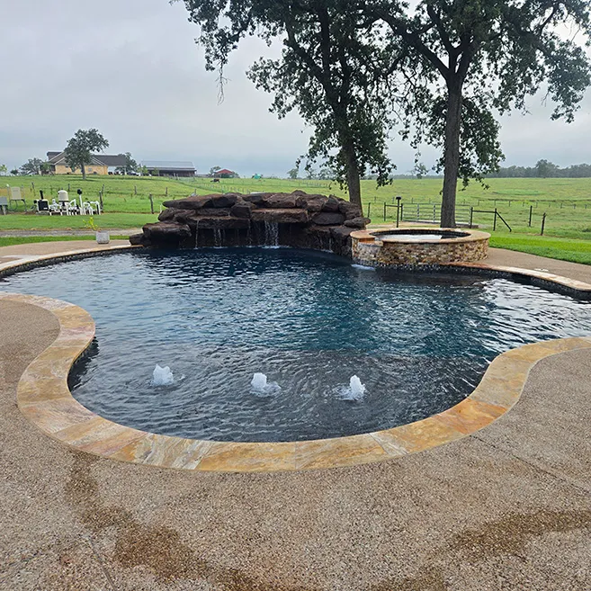 Custom pool with stone waterfall feature and in pool table.