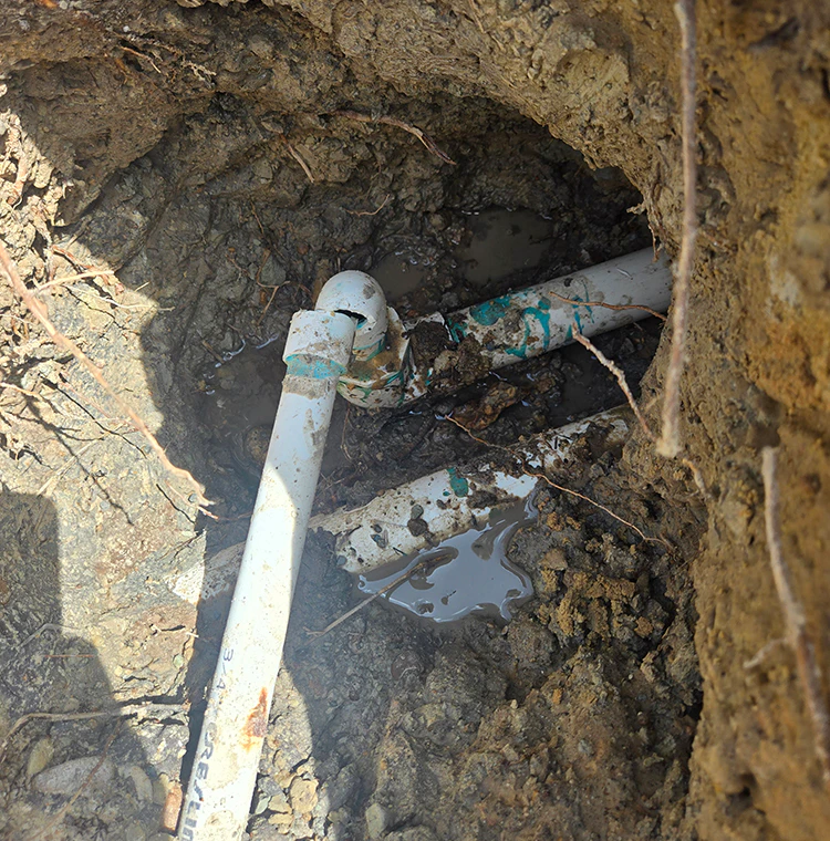 Repair work of structural leak being done shows exposed pvc piping to fix.