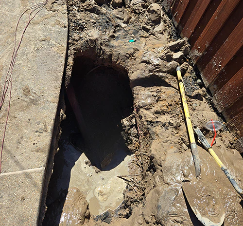 Structural leak photo with shovel out whole will mud all around.